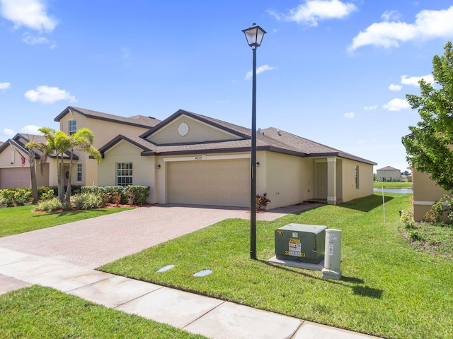 4235 Troon Pl, Fort Pierce, FL 34947 - view of front of house featuring stucco siding, a garage, decorative driveway, and a front lawn