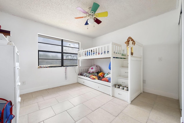 2426 SE Stonecrop St, Port Saint Lucie, FL 34984 - bedroom featuring a textured ceiling, baseboards, a ceiling fan, and light tile patterned floors