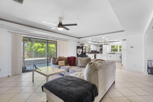 2426 SE Stonecrop St, Port Saint Lucie, FL 34984 - living room with light tile patterned floors, baseboards, a ceiling fan, and a raised ceiling