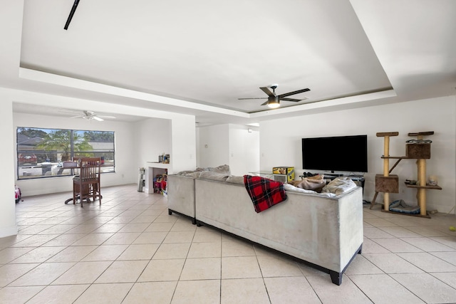 2426 SE Stonecrop St, Port Saint Lucie, FL 34984 - living room featuring a tray ceiling, light tile patterned flooring, baseboards, and a ceiling fan