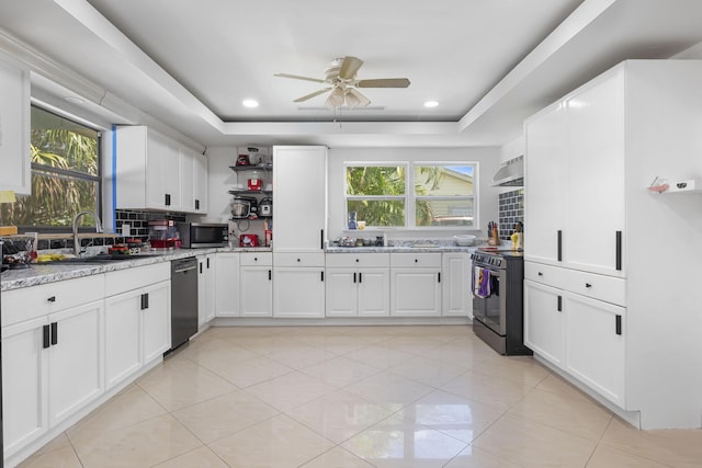 2426 SE Stonecrop St, Port Saint Lucie, FL 34984 - kitchen with a sink, stainless steel appliances, under cabinet range hood, white cabinets, and a tray ceiling