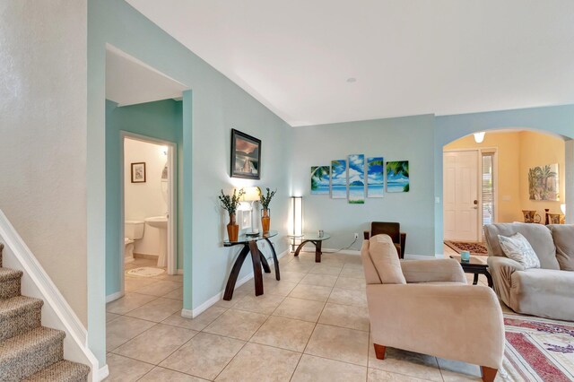 6805 Osage Cir, Greenacres, FL 33413 - living area featuring arched walkways, light tile patterned floors, baseboards, and stairs