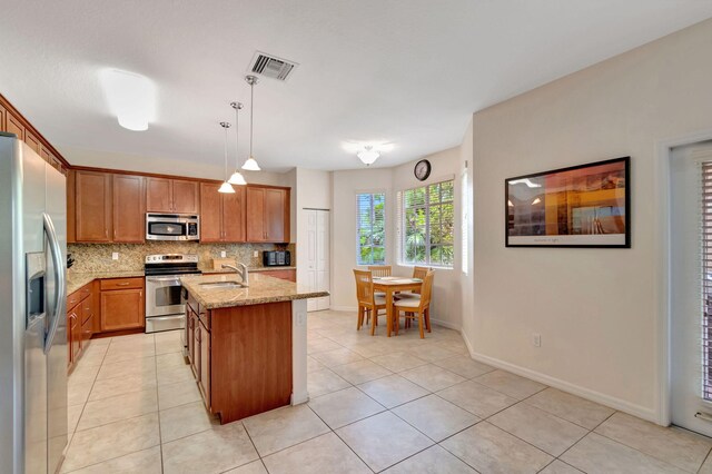 6805 Osage Cir, Greenacres, FL 33413 - kitchen with appliances with stainless steel finishes, tasteful backsplash, light stone countertops, and brown cabinets