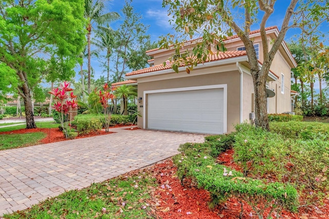 6805 Osage Cir, Greenacres, FL 33413 - view of front facade featuring decorative driveway, a garage, stucco siding, and a tiled roof