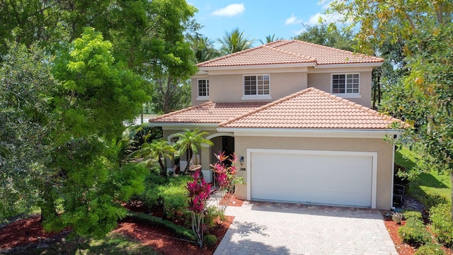 6805 Osage Cir, Greenacres, FL 33413 - mediterranean / spanish house with stucco siding, a tile roof, an attached garage, and decorative driveway