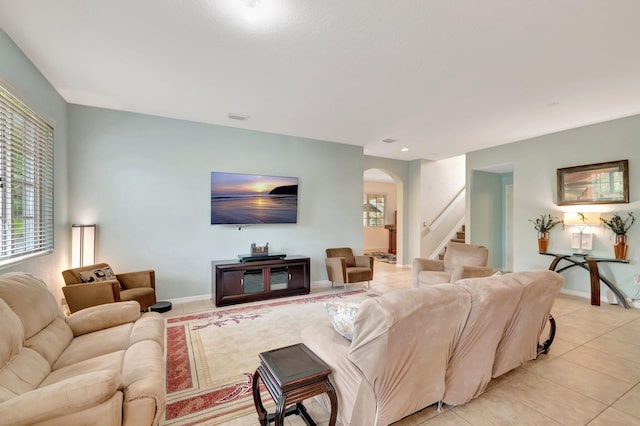 6805 Osage Cir, Greenacres, FL 33413 - living area featuring arched walkways, stairway, light tile patterned flooring, and baseboards