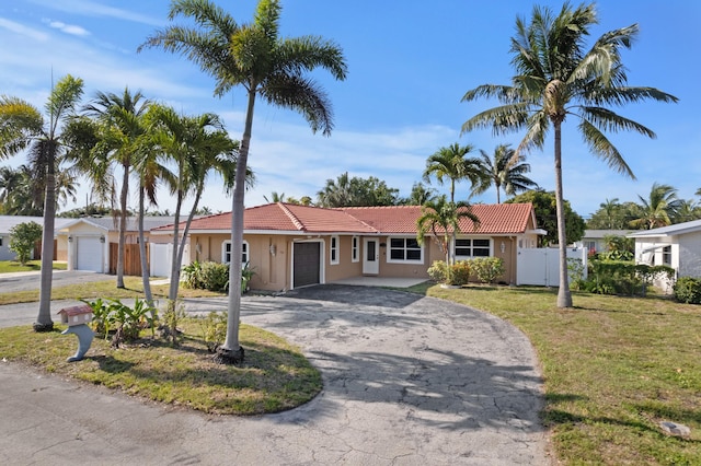 2650 NE 22nd St, Pompano Beach, FL 33062 - single story home with a tiled roof, an attached garage, curved driveway, and stucco siding