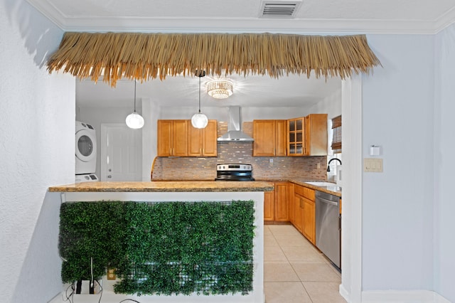 2650 NE 22nd St, Pompano Beach, FL 33062 - kitchen featuring wall chimney exhaust hood, appliances with stainless steel finishes, a sink, backsplash, and estacked washer and dryer