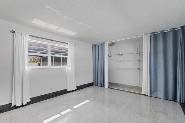 2650 NE 22nd St, Pompano Beach, FL 33062 - spare room with speckle patterned floor, a textured ceiling, and baseboards