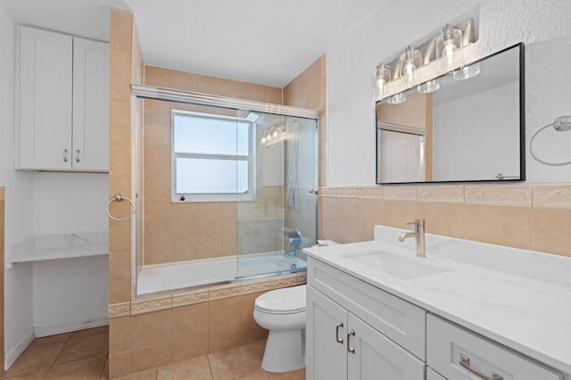 2650 NE 22nd St, Pompano Beach, FL 33062 - full bathroom with tile patterned floors, tiled shower / bath combo, toilet, vanity, and tile walls