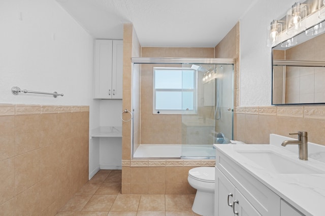 2650 NE 22nd St, Pompano Beach, FL 33062 - bathroom with tile walls, tile patterned floors, toilet, tiled shower / bath combo, and vanity