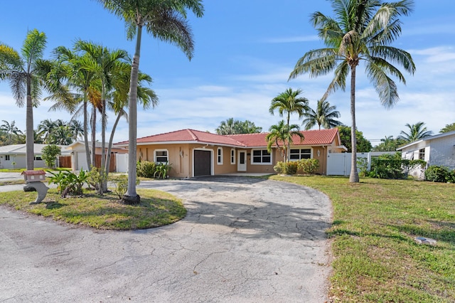 2650 NE 22nd St, Pompano Beach, FL 33062 - ranch-style home with a garage, curved driveway, a tile roof, and stucco siding