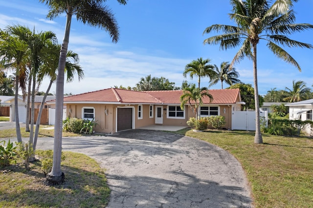 2650 NE 22nd St, Pompano Beach, FL 33062 - ranch-style home featuring an attached garage, asphalt driveway, a tiled roof, and stucco siding