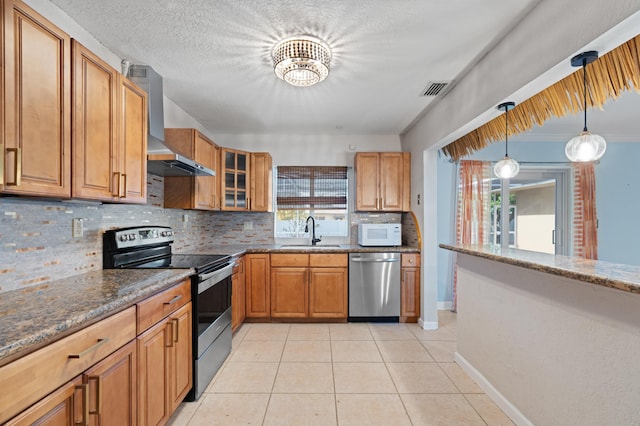 2650 NE 22nd St, Pompano Beach, FL 33062 - kitchen with appliances with stainless steel finishes, a sink, wall chimney exhaust hood, decorative backsplash, and plenty of natural light