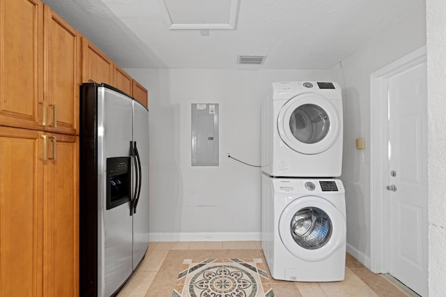 2650 NE 22nd St, Pompano Beach, FL 33062 - washroom with stacked washer / drying machine, electric panel, light tile patterned floors, and baseboards