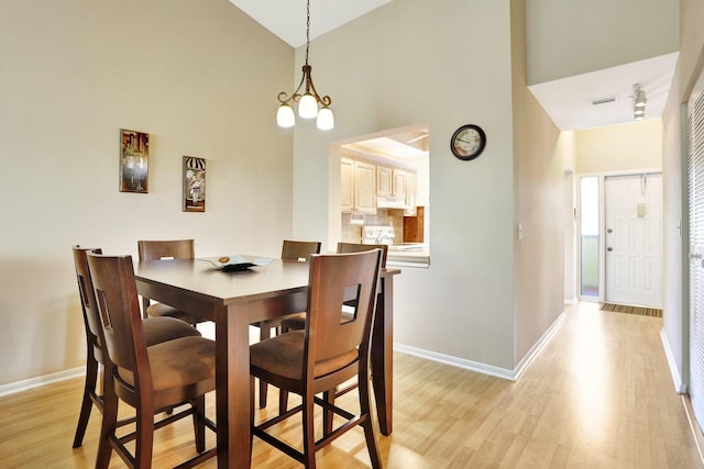 1961 SW 15th St Unit 82, Deerfield Beach, FL 33442 - dining room with high vaulted ceiling, light wood-type flooring, baseboards, and a chandelier