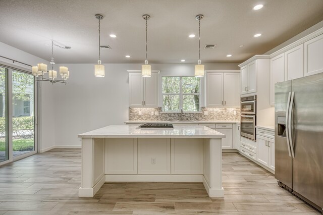 179 Tresana Blvd Unit 145, Jupiter, FL 33478 - kitchen with stainless steel appliances, a center island, plenty of natural light, a sink, and recessed lighting