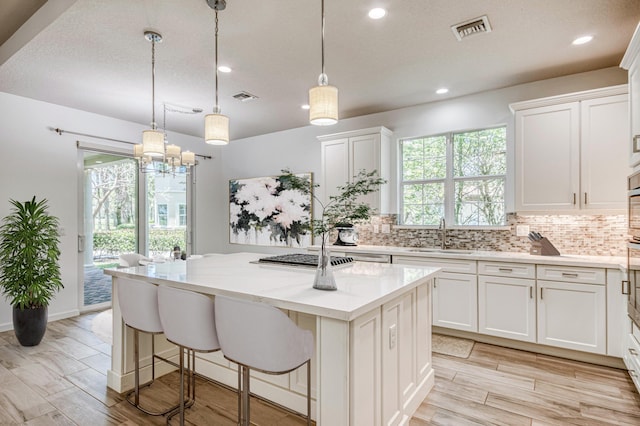 179 Tresana Blvd Unit 145, Jupiter, FL 33478 - kitchen with a sink, plenty of natural light, a center island, tasteful backsplash, and recessed lighting
