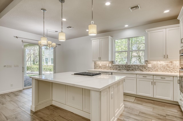 179 Tresana Blvd Unit 145, Jupiter, FL 33478 - kitchen featuring a sink, a kitchen island, plenty of natural light, backsplash, and recessed lighting