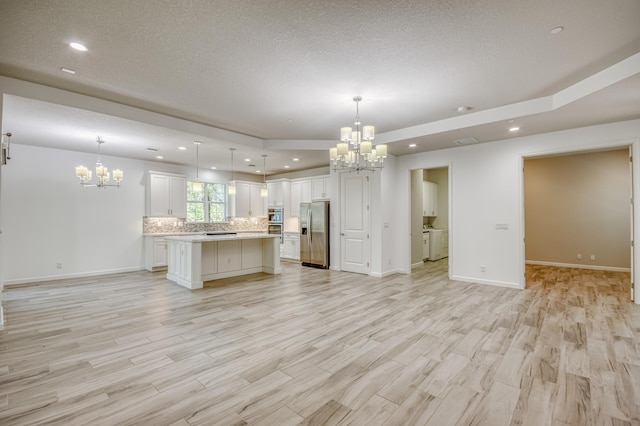 179 Tresana Blvd Unit 145, Jupiter, FL 33478 - kitchen featuring a chandelier, open floor plan, stainless steel fridge, light countertops, and recessed lighting