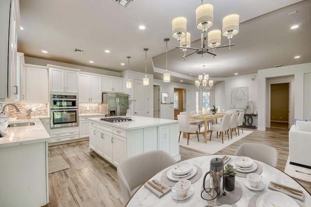 179 Tresana Blvd Unit 145, Jupiter, FL 33478 - kitchen featuring a sink, a chandelier, stainless steel appliances, recessed lighting, and decorative backsplash