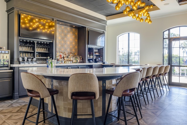 179 Tresana Blvd Unit 145, Jupiter, FL 33478 - indoor dry bar featuring crown molding, healthy amount of natural light, a chandelier, and pendant lighting