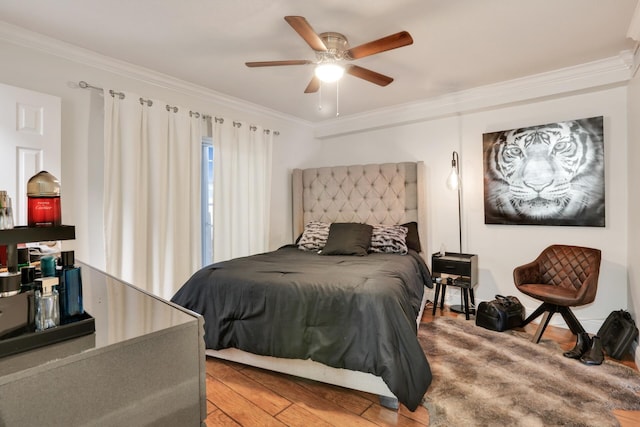 bedroom featuring ornamental molding, wood finished floors, and a ceiling fan