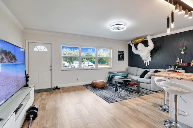 living area with crown molding, light wood-type flooring, and baseboards