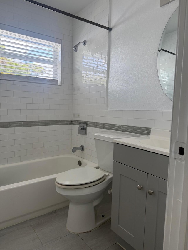 full bathroom featuring tile walls, tile patterned flooring, shower / bathtub combination, vanity, and toilet