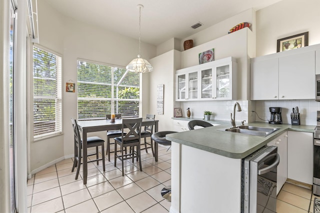 kitchen with a healthy amount of sunlight, visible vents, a sink, stainless steel appliances, and white cabinets