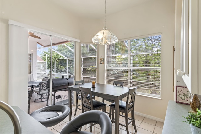 dining area with a sunroom, baseboards, light tile patterned floors, and a healthy amount of sunlight