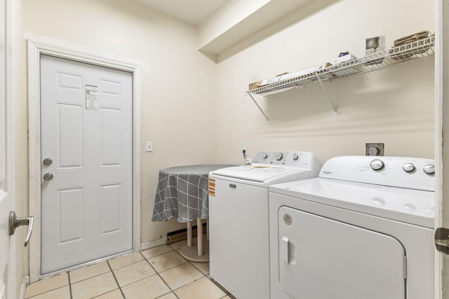laundry area with laundry area, washer and clothes dryer, and light tile patterned floors