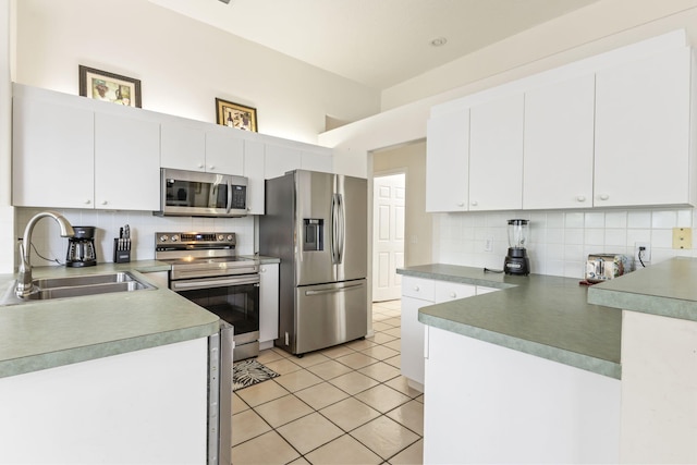 kitchen featuring white cabinets, stainless steel appliances, tasteful backsplash, and a sink