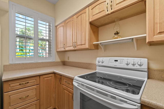 3003 Fairway Dr N, Jupiter, FL 33477 - kitchen with white range with electric stovetop, light countertops, light brown cabinetry, and open shelves