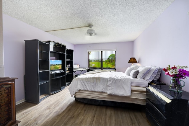 13403 Touchstone Pl Unit A-202, Palm Beach Gardens, FL 33418 - bedroom featuring wood finished floors, a textured ceiling, and a ceiling fan