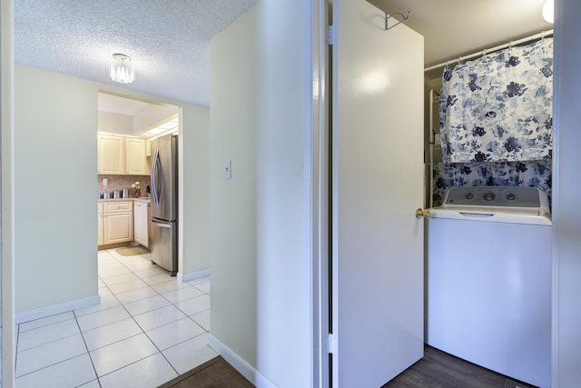 13403 Touchstone Pl Unit A-202, Palm Beach Gardens, FL 33418 - corridor featuring washer / clothes dryer, light tile patterned flooring, baseboards, and a textured ceiling