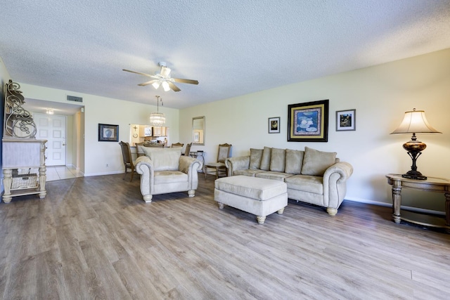 13403 Touchstone Pl Unit A-202, Palm Beach Gardens, FL 33418 - living area featuring ceiling fan, a textured ceiling, wood finished floors, and baseboards
