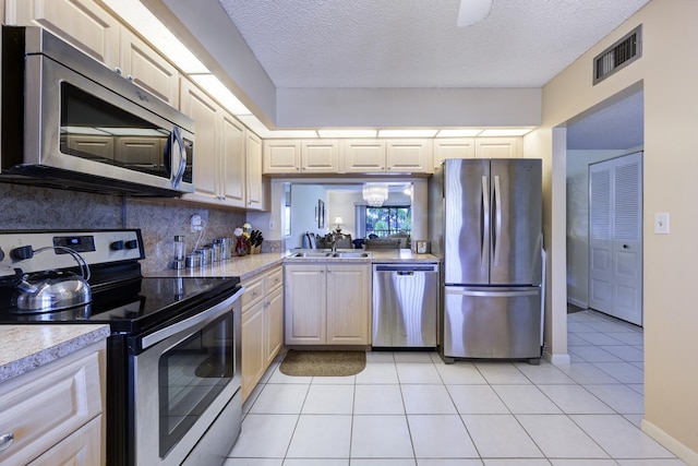 13403 Touchstone Pl Unit A-202, Palm Beach Gardens, FL 33418 - kitchen featuring stainless steel appliances, light countertops, backsplash, a textured ceiling, and light tile patterned floors
