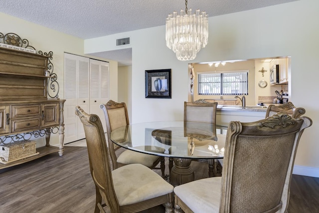 13403 Touchstone Pl Unit A-202, Palm Beach Gardens, FL 33418 - dining area featuring dark wood-style flooring, a textured ceiling, and a chandelier