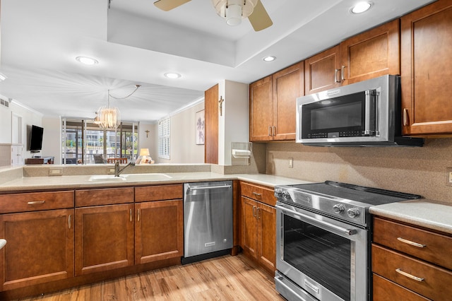 911 Gardenia Dr Unit 154, Delray Beach, FL 33483 - kitchen with a sink, brown cabinetry, stainless steel appliances, and ceiling fan with notable chandelier