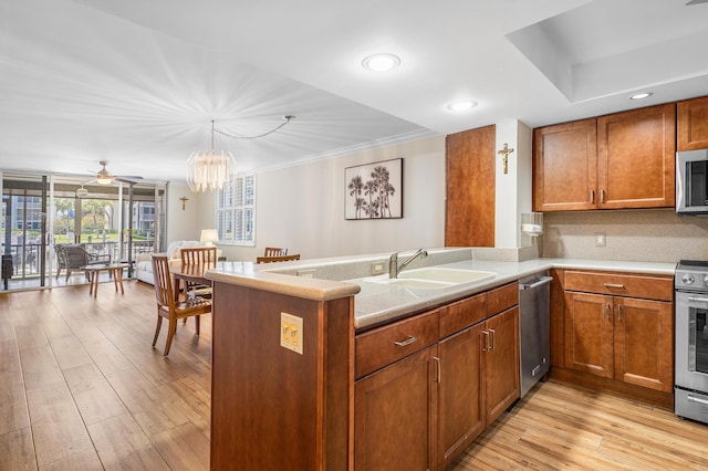 911 Gardenia Dr Unit 154, Delray Beach, FL 33483 - kitchen featuring appliances with stainless steel finishes, brown cabinetry, a sink, a peninsula, and light wood-type flooring