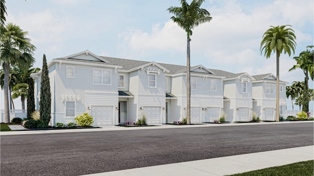 view of property with an attached garage, stucco siding, and a residential view