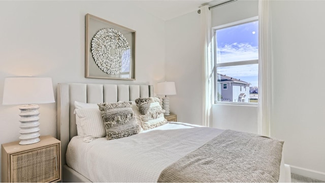 carpeted bedroom featuring baseboards and multiple windows