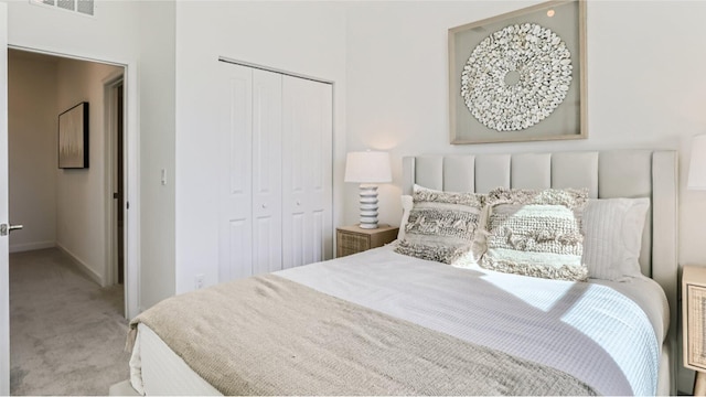 bedroom featuring baseboards, light carpet, a closet, and visible vents