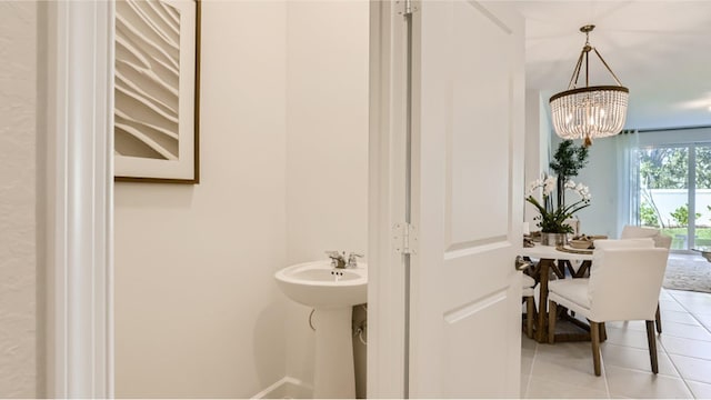 bathroom with a notable chandelier and tile patterned floors