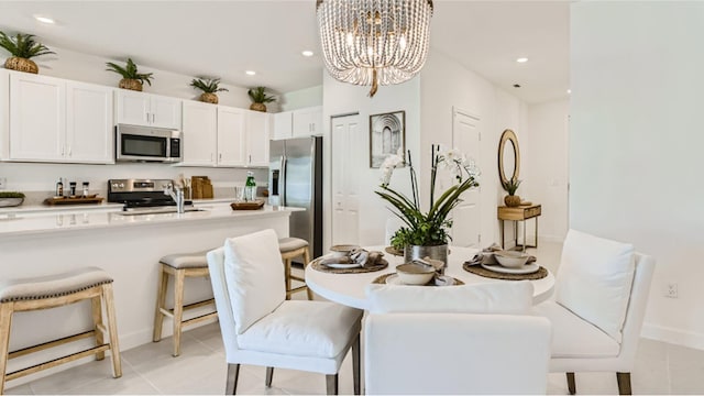 dining area with an inviting chandelier, light tile patterned floors, and recessed lighting
