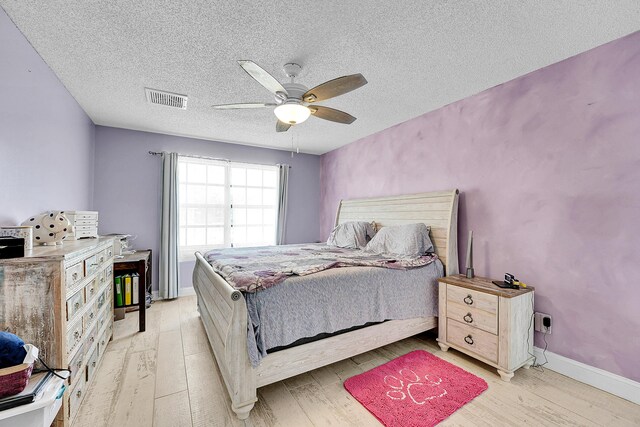 1742 SW Hampshire Ln, Port Saint Lucie, FL 34953 - bedroom featuring light wood-style flooring, a textured ceiling, and ceiling fan