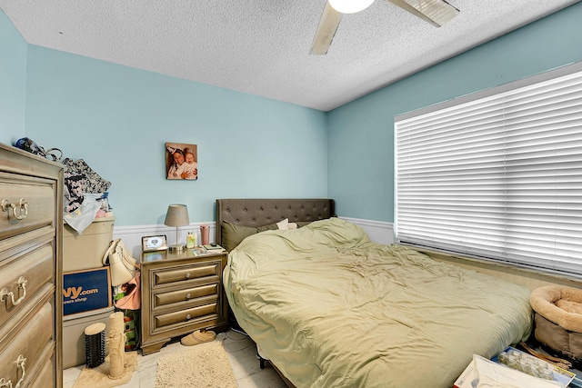 1742 SW Hampshire Ln, Port Saint Lucie, FL 34953 - bedroom with a wainscoted wall, a textured ceiling, and a ceiling fan