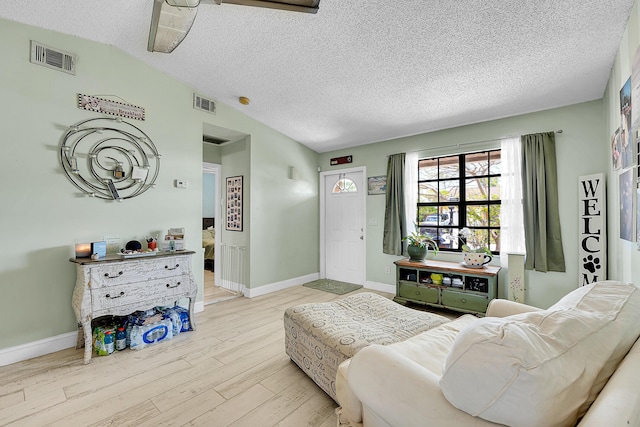 1742 SW Hampshire Ln, Port Saint Lucie, FL 34953 - living room with wood finished floors, a textured ceiling, lofted ceiling, and baseboards