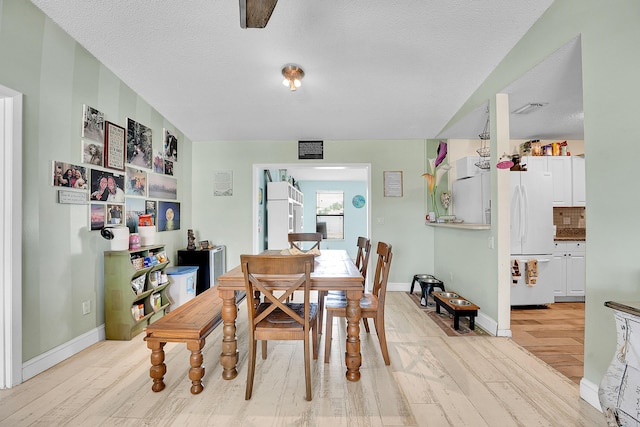 1742 SW Hampshire Ln, Port Saint Lucie, FL 34953 - dining area featuring light wood-style flooring, baseboards, and a textured ceiling